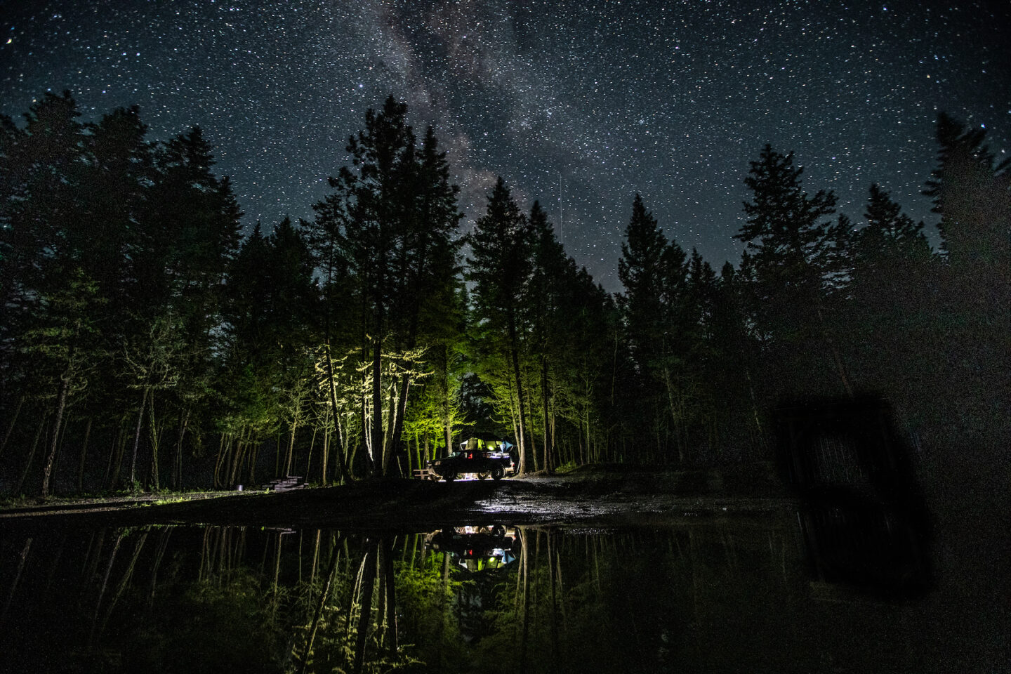 view of a capsite across a lake and a starry sky