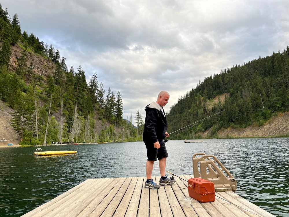 Man on a dock on a lake.