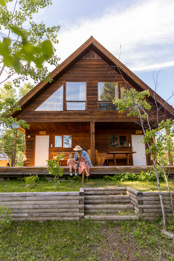 Family sitting in front of a cabin.