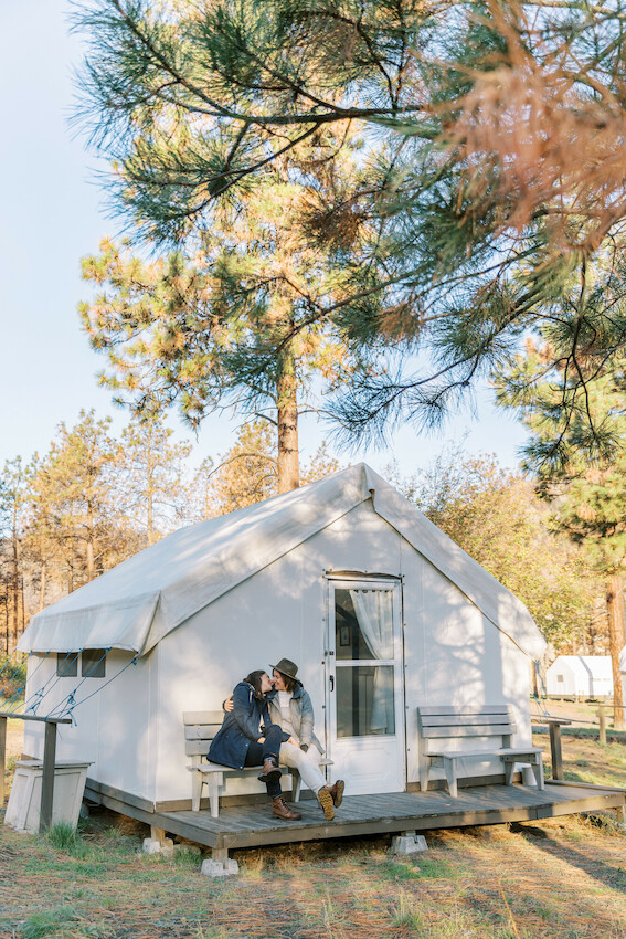 Couple sitting in front of their glamping tent.